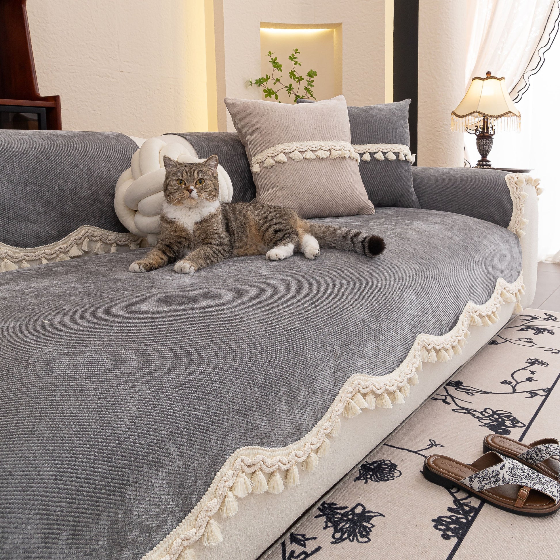 Chenille Sofa Cover Towel – Non-Slip, Washable Pets Couch Protector with Tassels covering a sofa with a cat laying on top