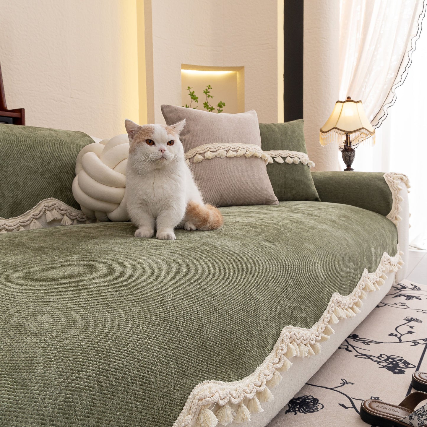 Chenille Sofa Cover Towel – Non-Slip, Washable Pets Couch Protector with Tassels on a sofa with a cat sitting on it.