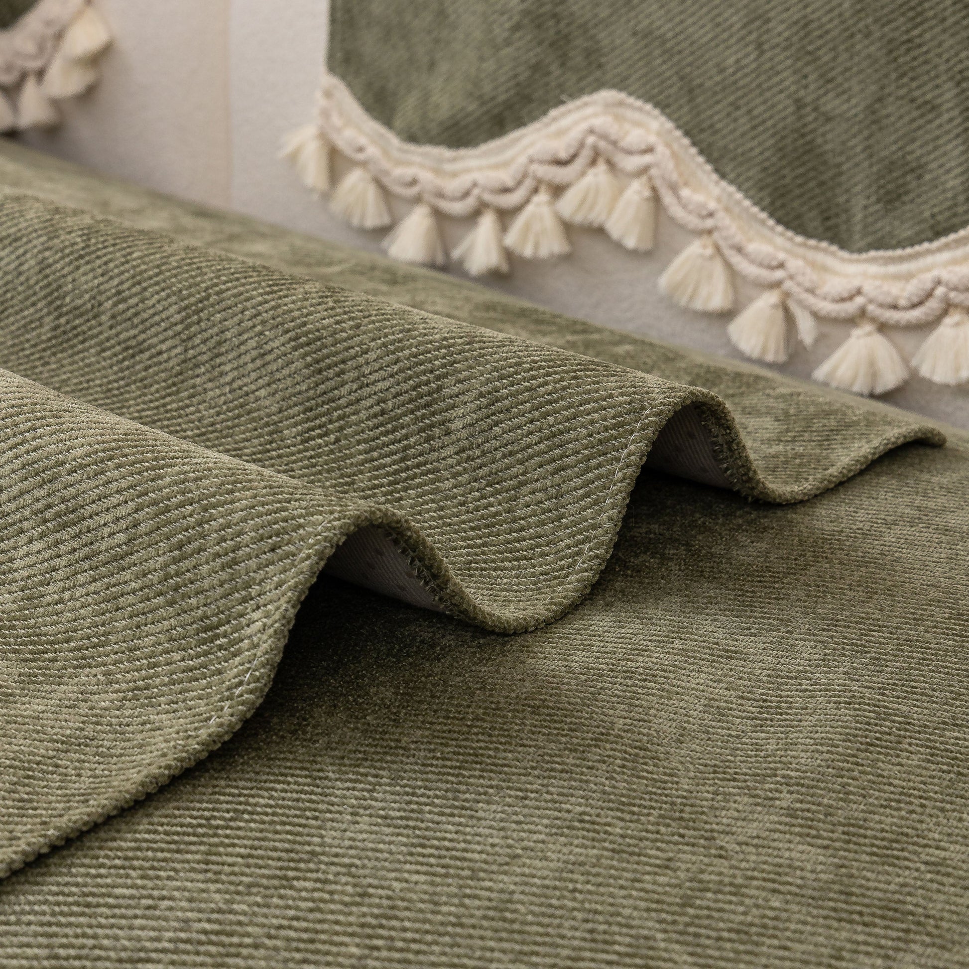 Chenille Sofa Cover Towel – Non-Slip, Washable Pets Couch Protector with Tassels featuring green fabric and ivory tassels.