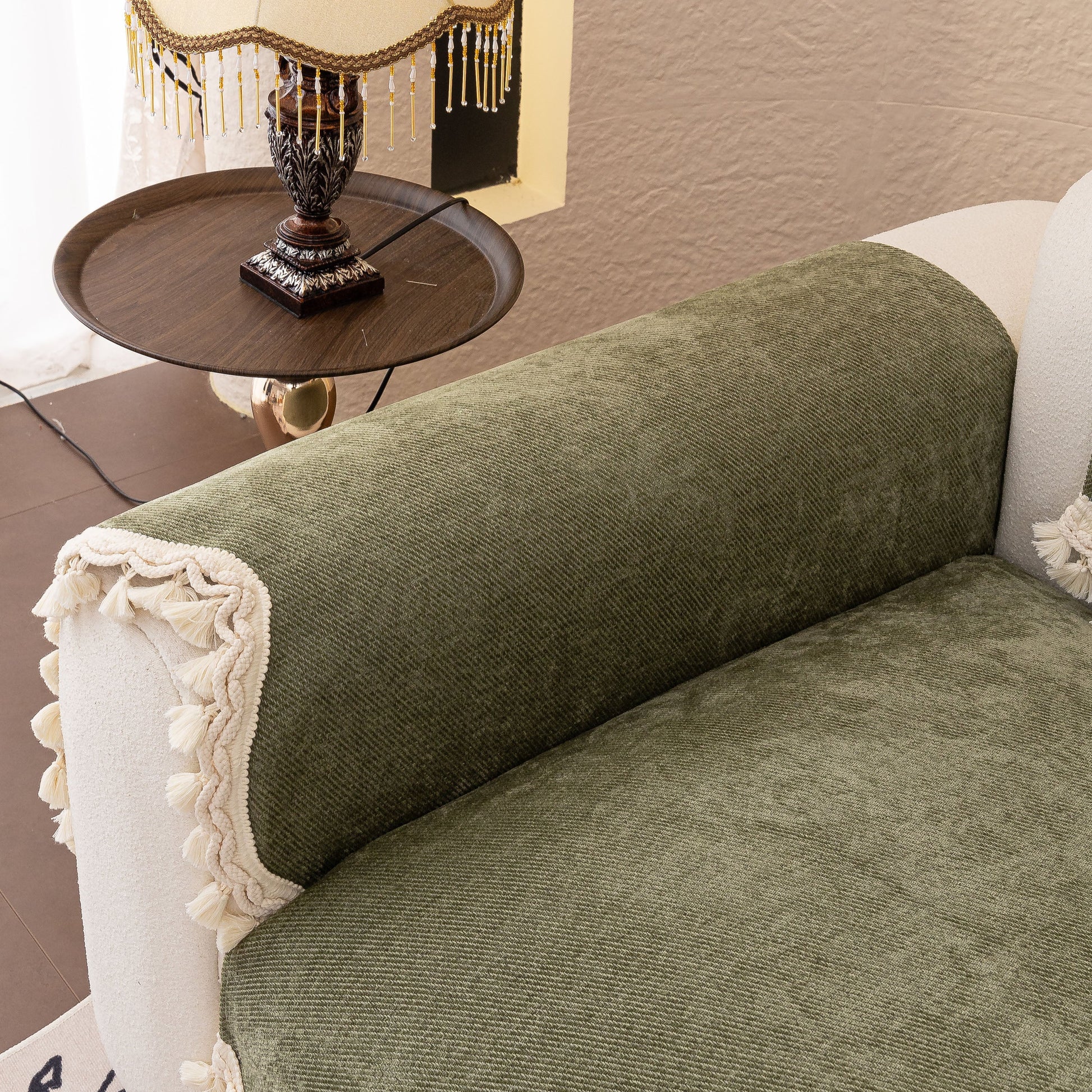 Chenille Sofa Cover Towel – Non-Slip, Washable Pets Couch Protector with Tassels on a green sofa armrest
