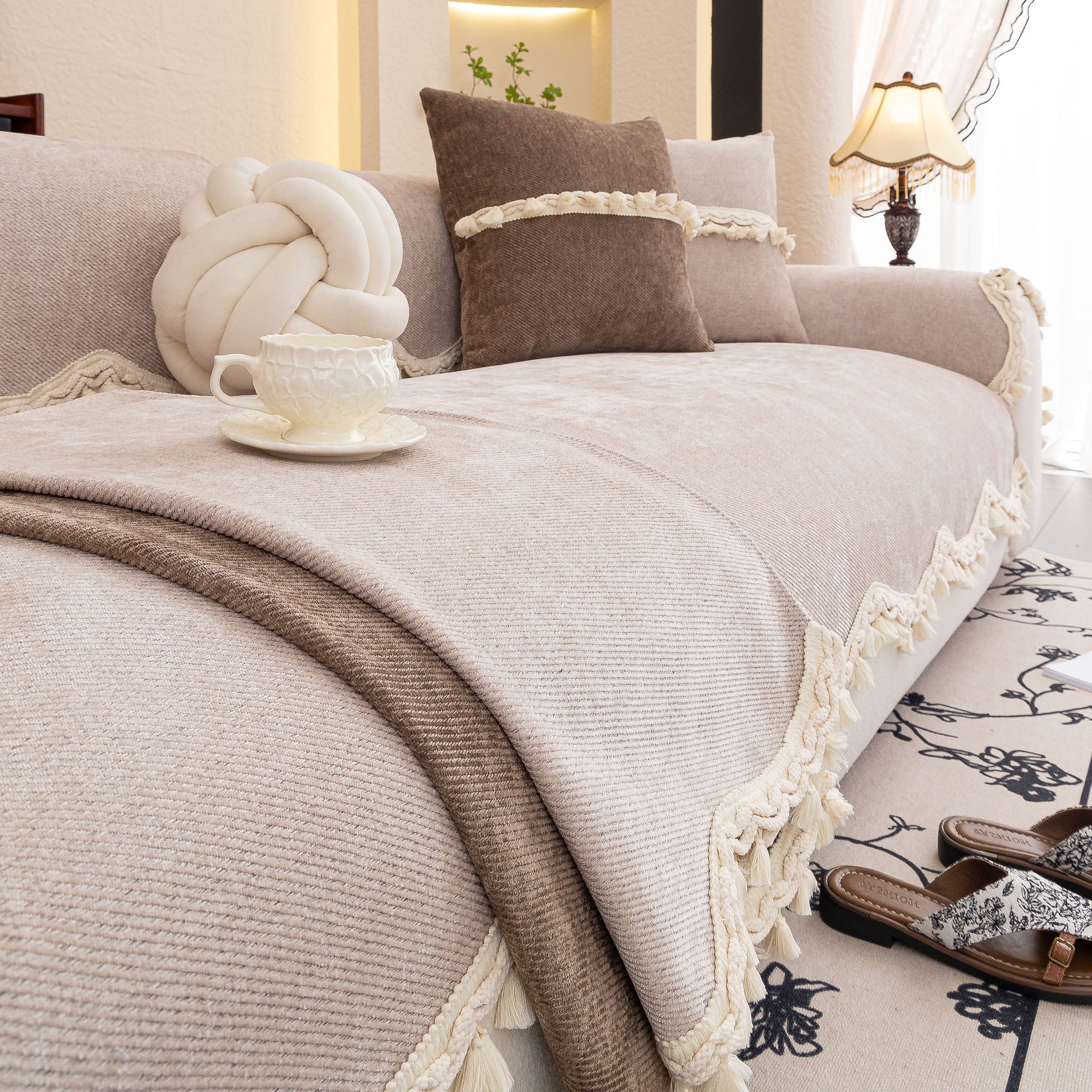 Chenille Sofa Cover Towel – Non-Slip, Washable Pets Couch Protector with Tassels in elegant beige living room setting with decorative elements.