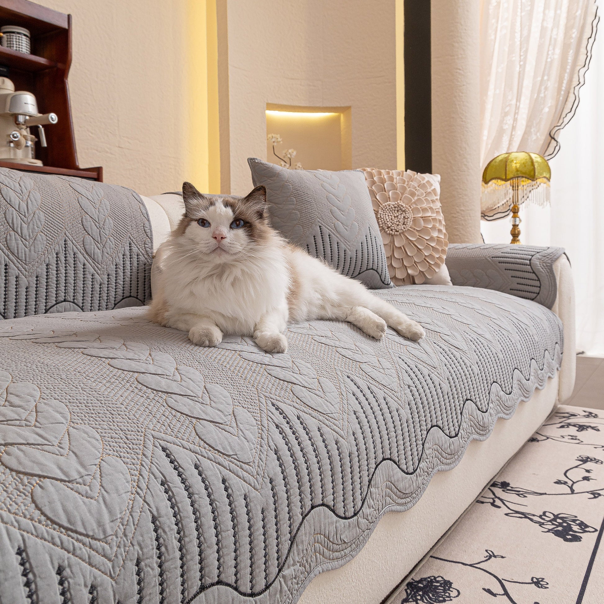 Cat lounging on sofa with 3D Quilted Thick Cotton Sofa Cover Non-Slip Couch Throw for Fabric & Leather Sofas displayed in living room.