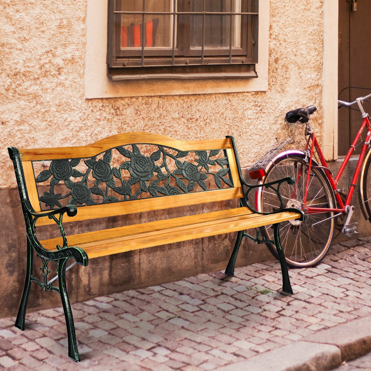 Garden Bench Chair Outdoor Wooden Loveseat with Iron Armrest on a cobblestone street next to a red bicycle and window.