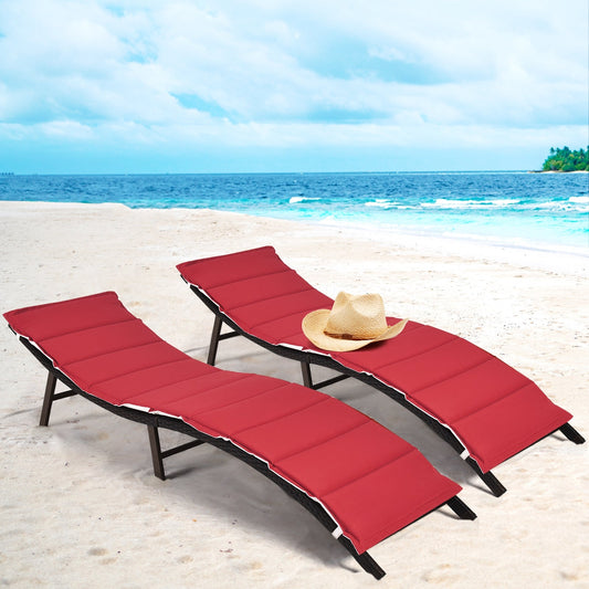 2Pcs Folding Patio Lounger Chair with red cushions on a sandy beach with ocean background.