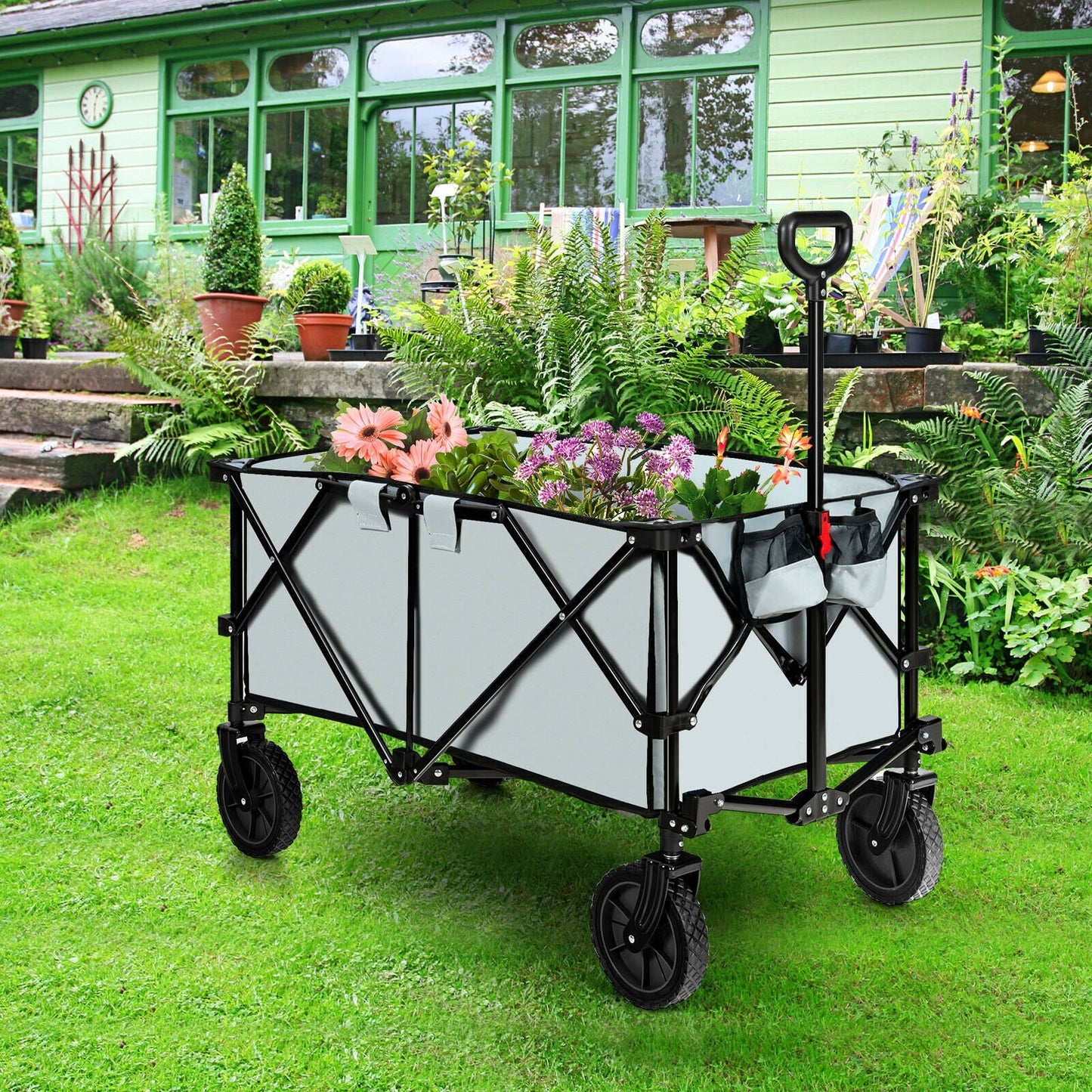 Outdoor Folding Wagon Cart with Adjustable Handle and Universal Wheels-Gray in a garden setting