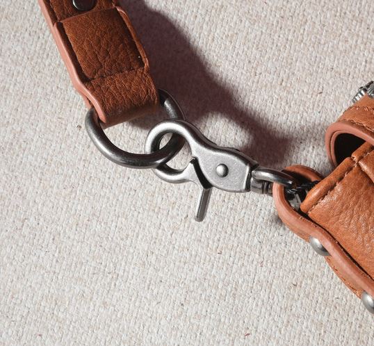 Close-up of metal clasp and leather strap on Montana West Fringe Mariposa Concho Collection Crossbody bag.