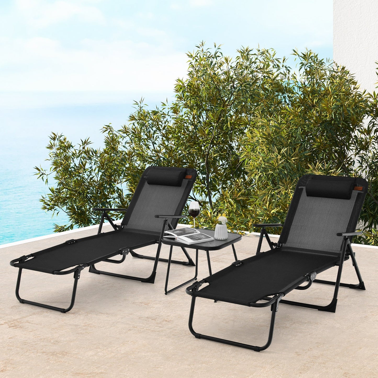 3 Pieces Patio Folding Chaise Lounge Set with PVC Tabletop-Black on a terrace by the sea.