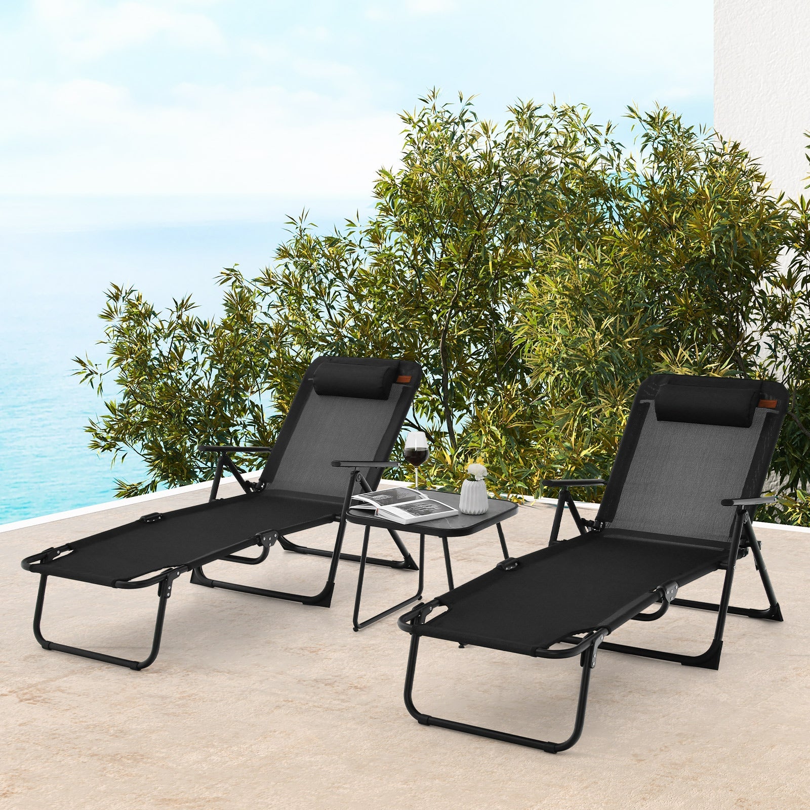 3 Pieces Patio Folding Chaise Lounge Set with PVC Tabletop-Black on a terrace by the sea.