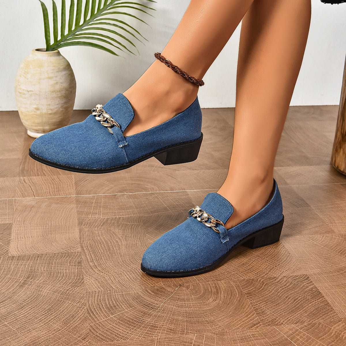 Blue women's loafers with chain detail on hardwood floor, featuring block heels and a modern design