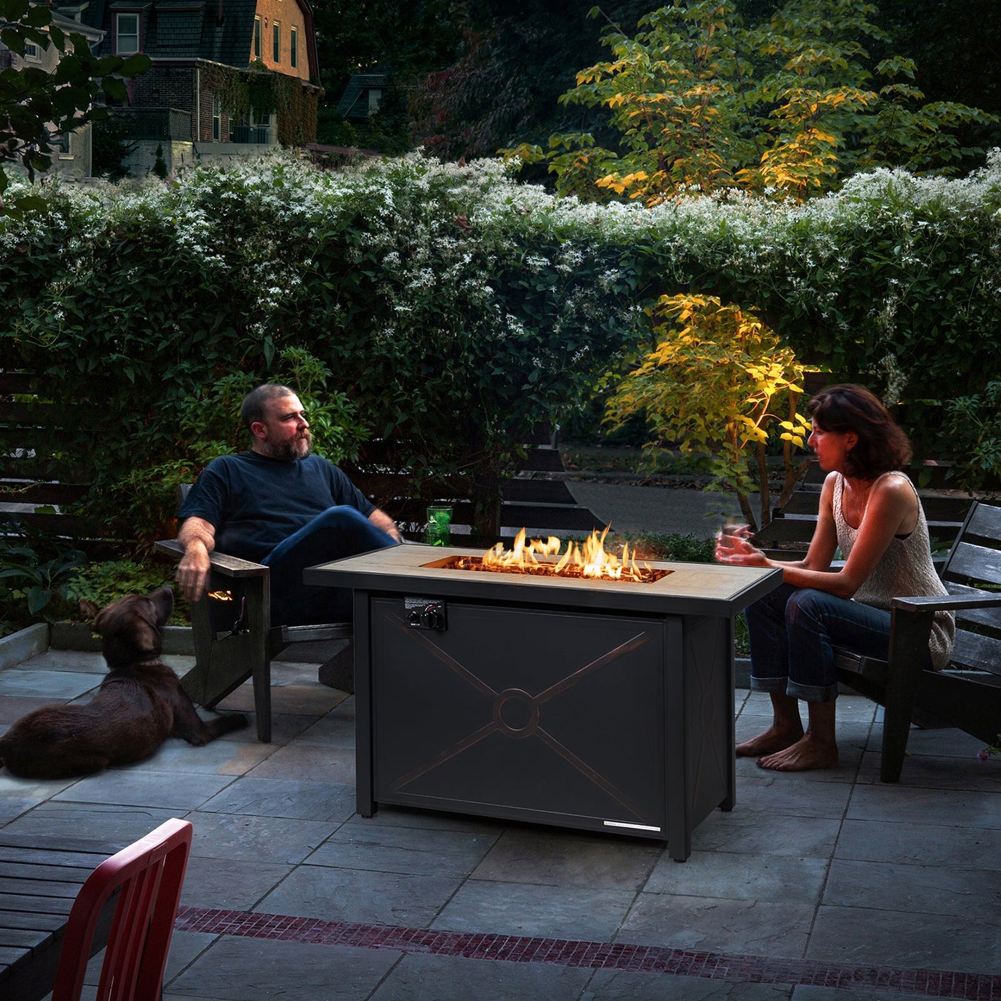 42 Inch 60000 BTU Propane Fire Pit Table with Ceramic Tabletop on a patio with people enjoying the warmth.