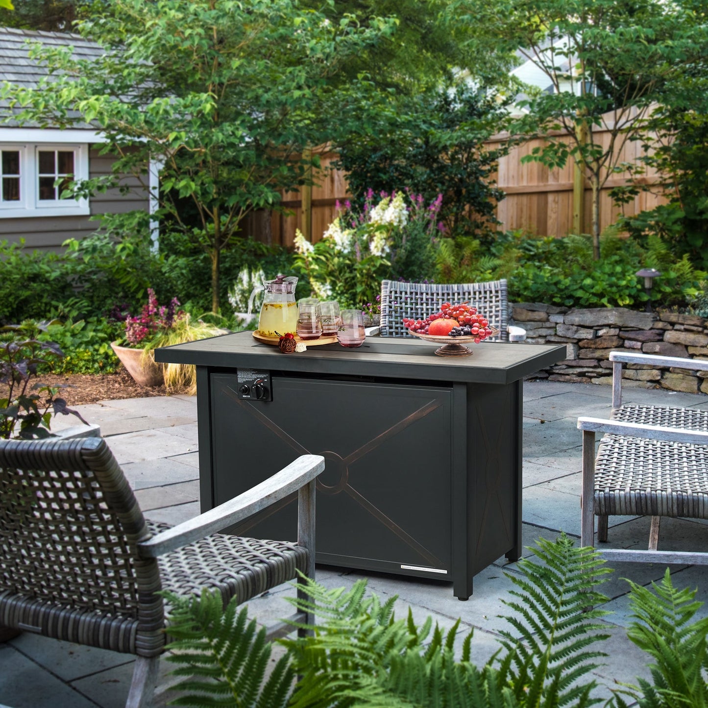 42 Inch 60000 BTU Propane Fire Pit Table with Ceramic Tabletop in outdoor garden setting with chairs