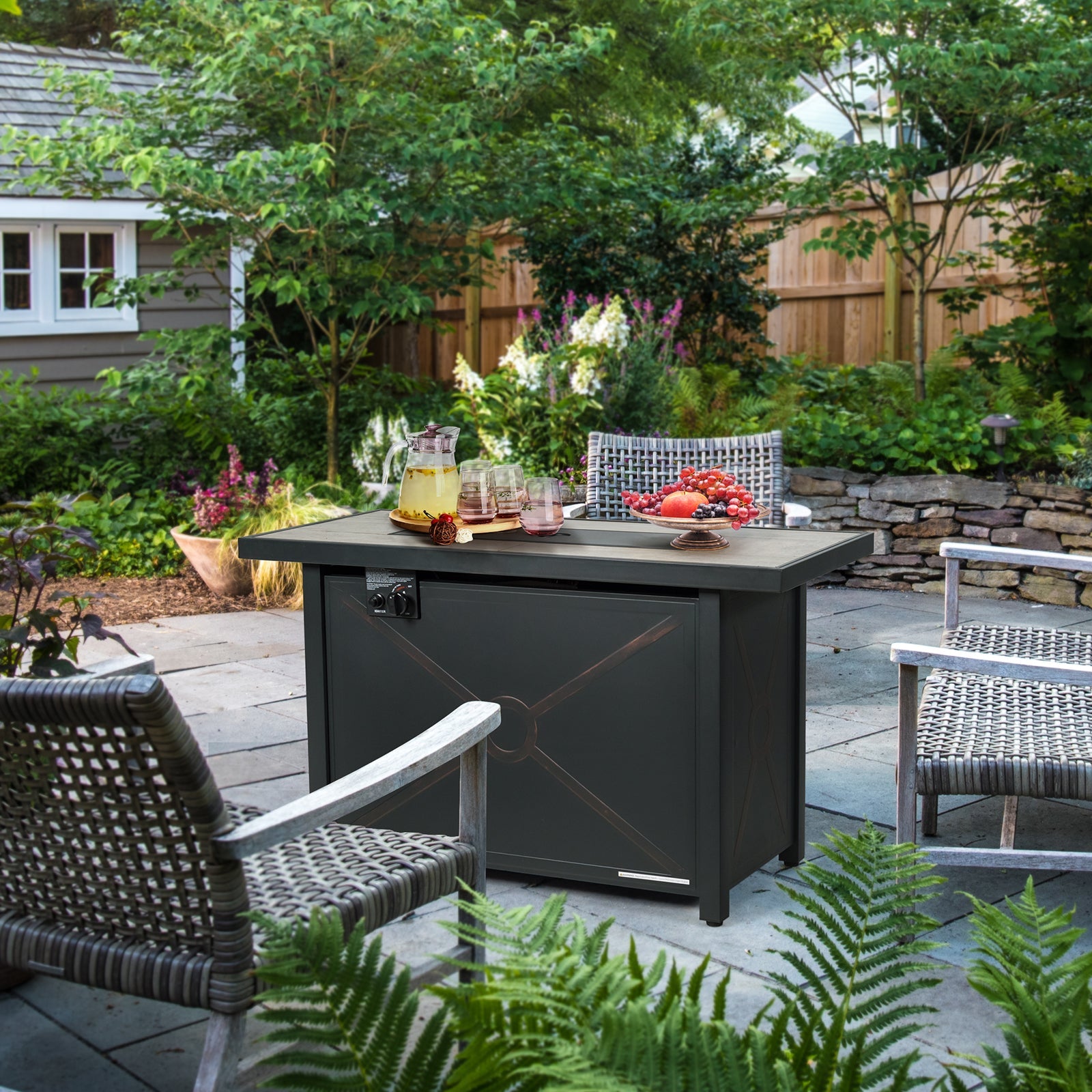42 Inch 60000 BTU Propane Fire Pit Table with Ceramic Tabletop in outdoor garden setting with chairs