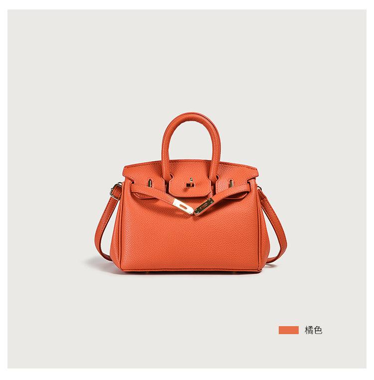 Orange leather handbag with gold accents, featuring a top handle and shoulder strap.