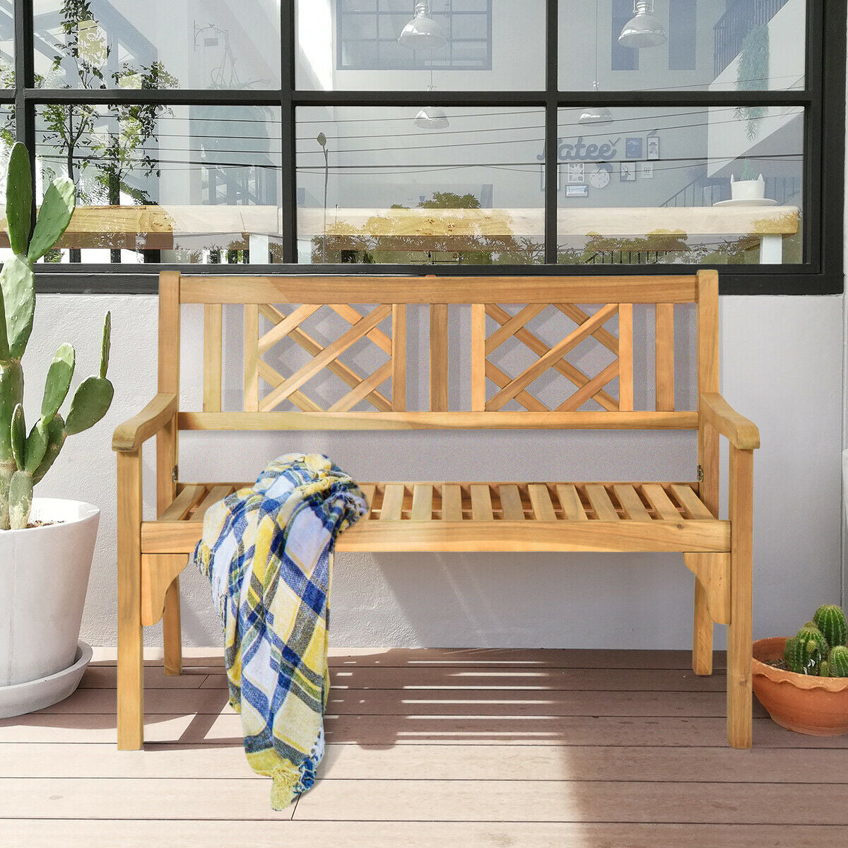 Patio Foldable Bench with Curved Backrest and Armrest made of acacia wood, placed on a patio with a colorful blanket