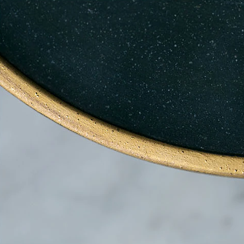 Close-up of Galileo Tableware plate with matte green glaze and golden ring, crafted in porcelain. Dishwasher and freezer safe.