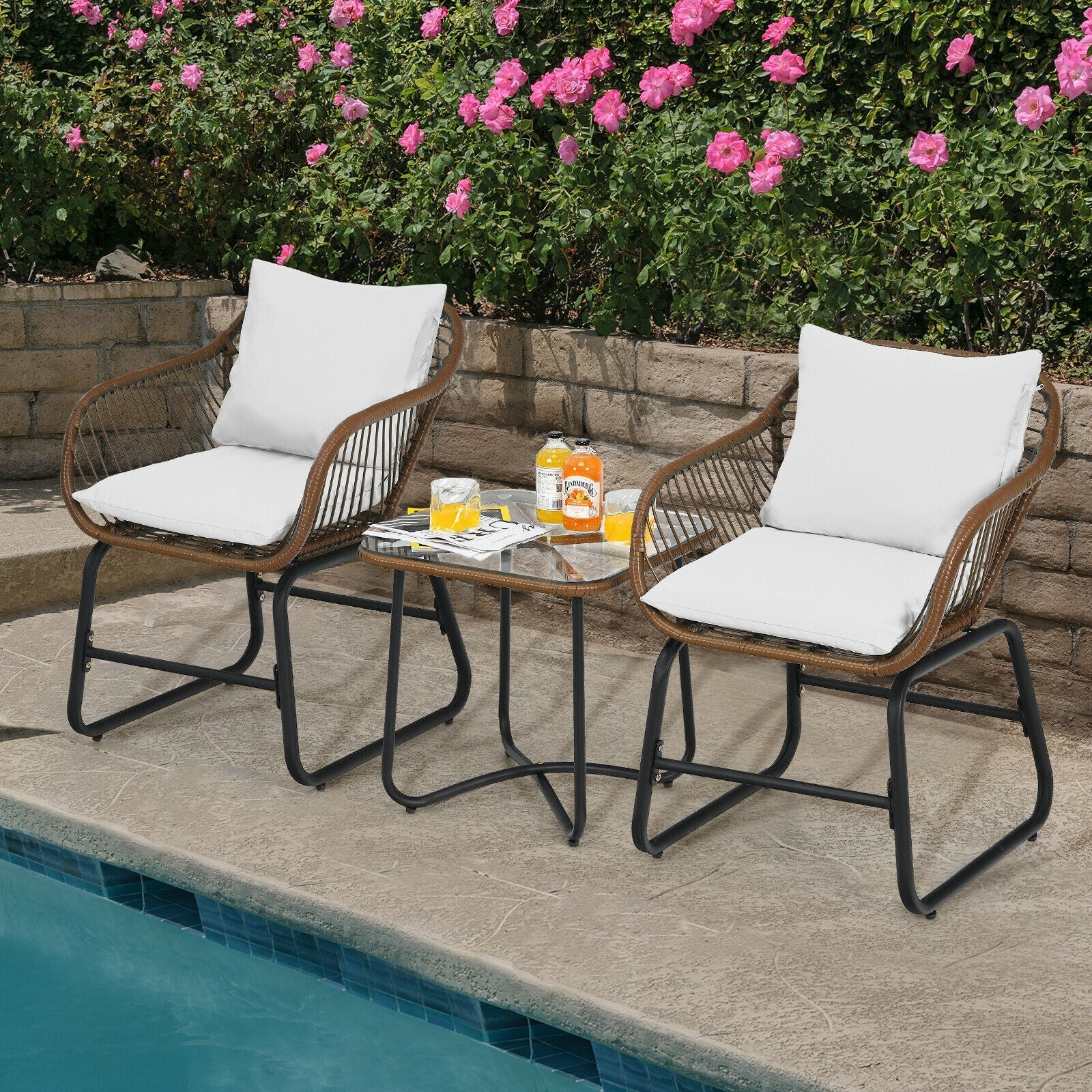 3 Pieces Patio Rattan Bistro Set Cushioned Chair Glass Table Deck-White by poolside with pink flowers and green plants in background