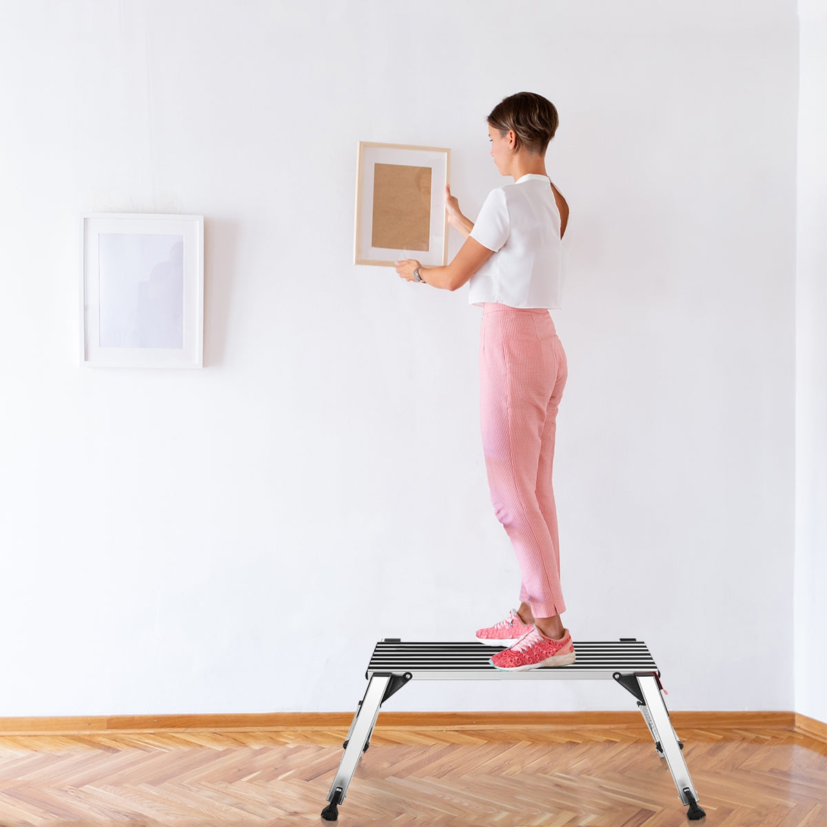 330 lbs Aluminum Folding Non-slip Drywall Step Stool Ladder in use for hanging a picture, showcasing safety and versatility.