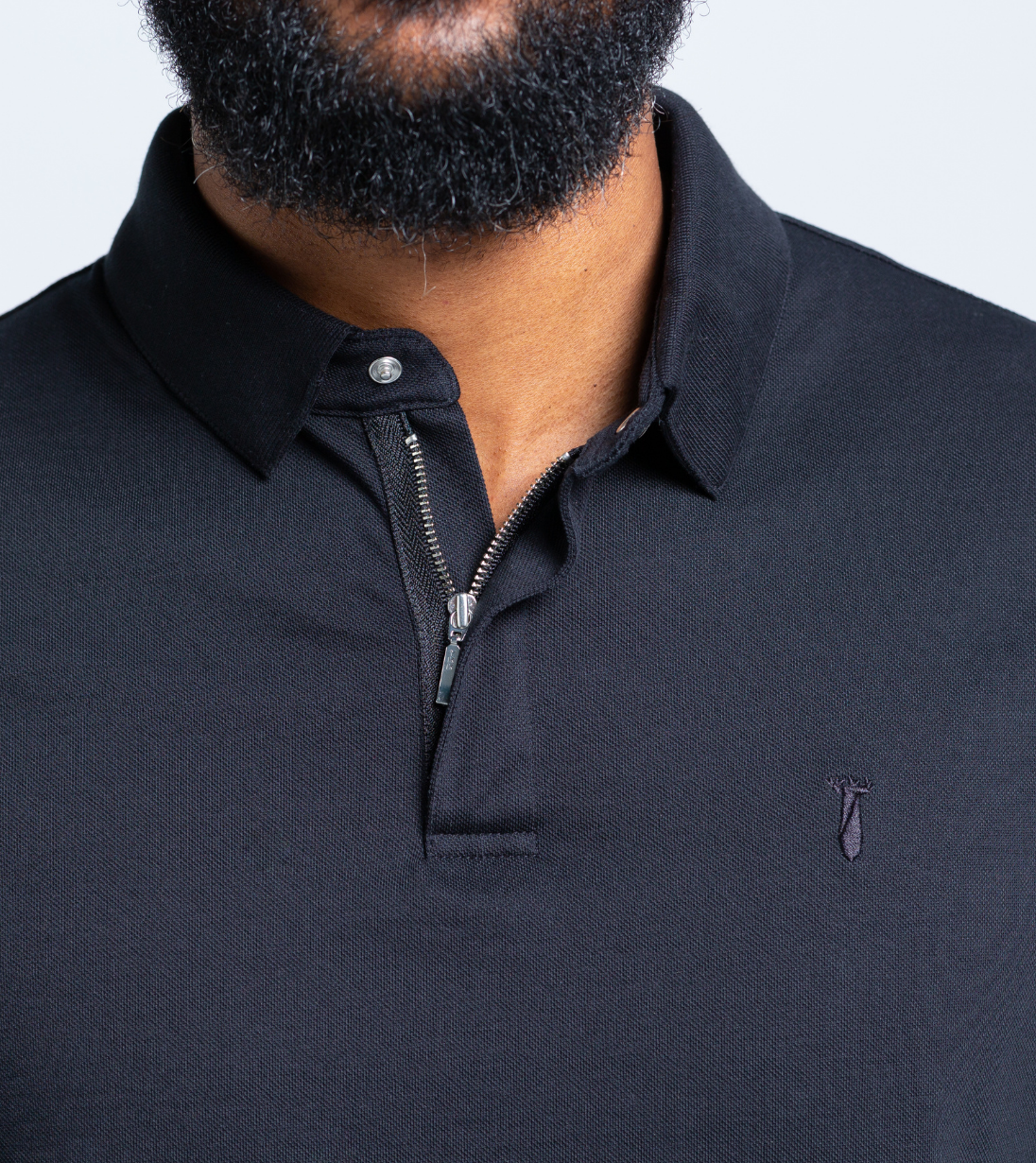 Man wearing black Short Sleeve Perfect Polo with StaySharp™ Collar and hidden microfiber cloth for modern style and convenience.