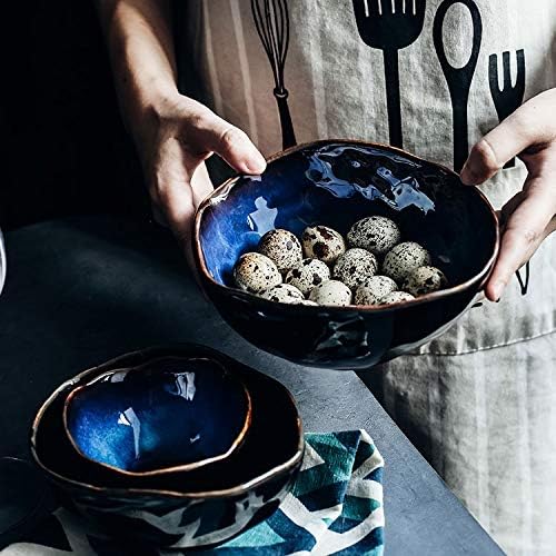 Person holding a bowl from Blue European Porcelain Dinnerware Set (Plates and Bowls), featuring hand-painted dark blue porcelain.