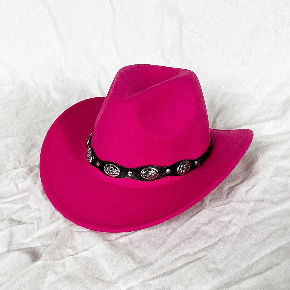 Hot pink cowboy hat with black concho band on white background.