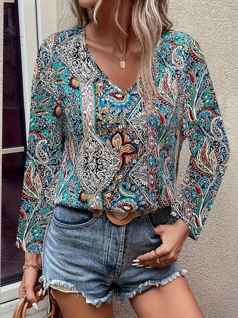 Woman wearing a Boho Paisley V-Neck Long Sleeved Shirt with vibrant green paisley print, paired with denim shorts.