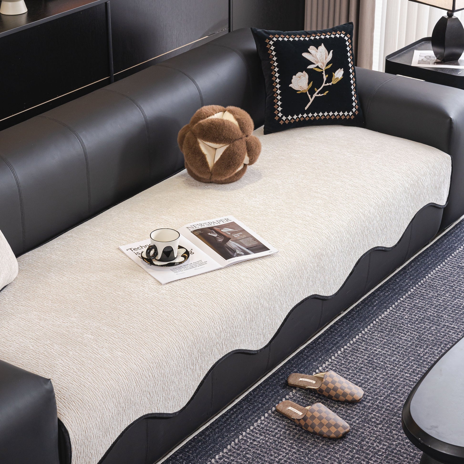 Modern living room with Chenille Couch Cover with Scalloped Edge on black sofa, featuring plush texture and elegant design.