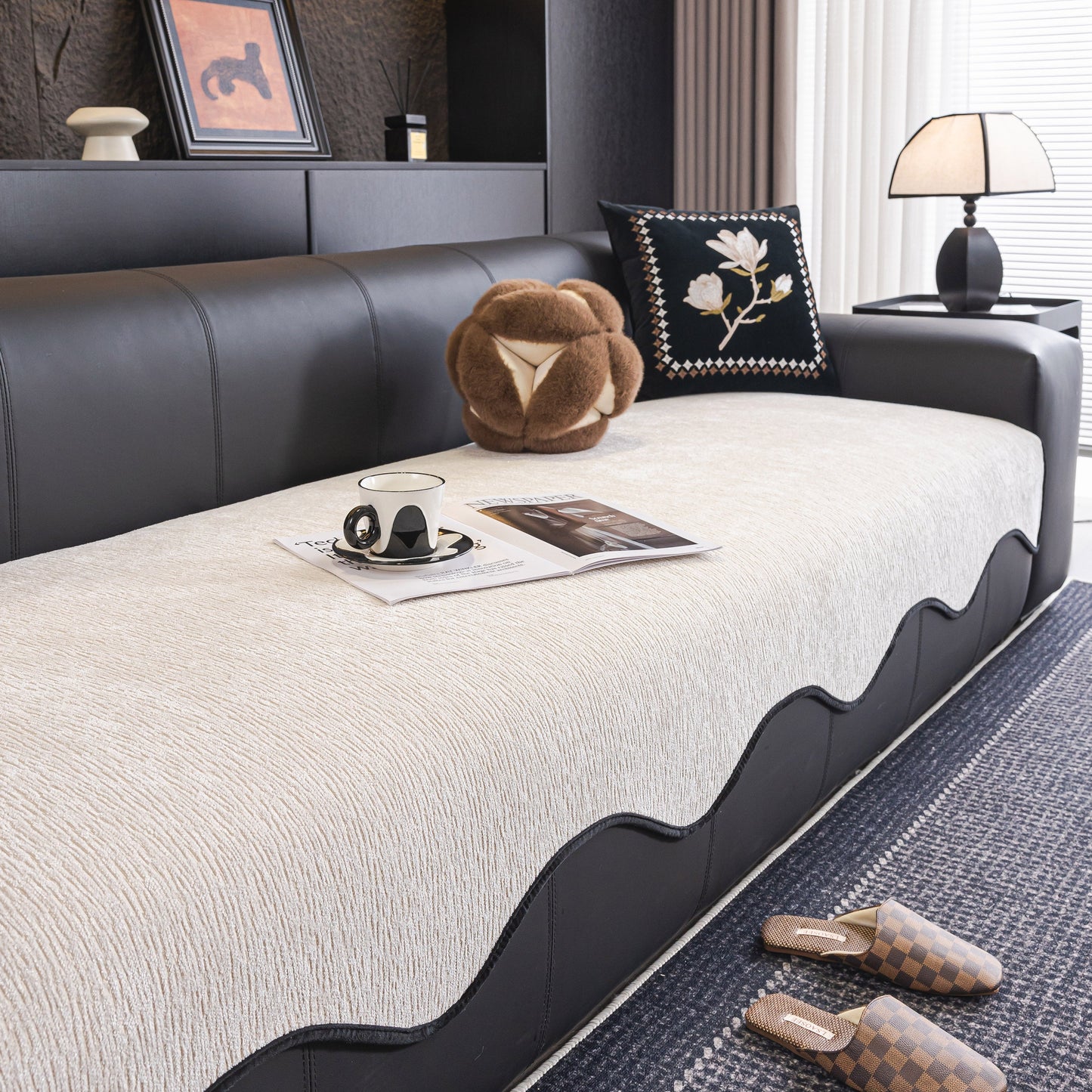Chenille Couch Cover with Scalloped Edge on a black leather sofa in a modern living room.