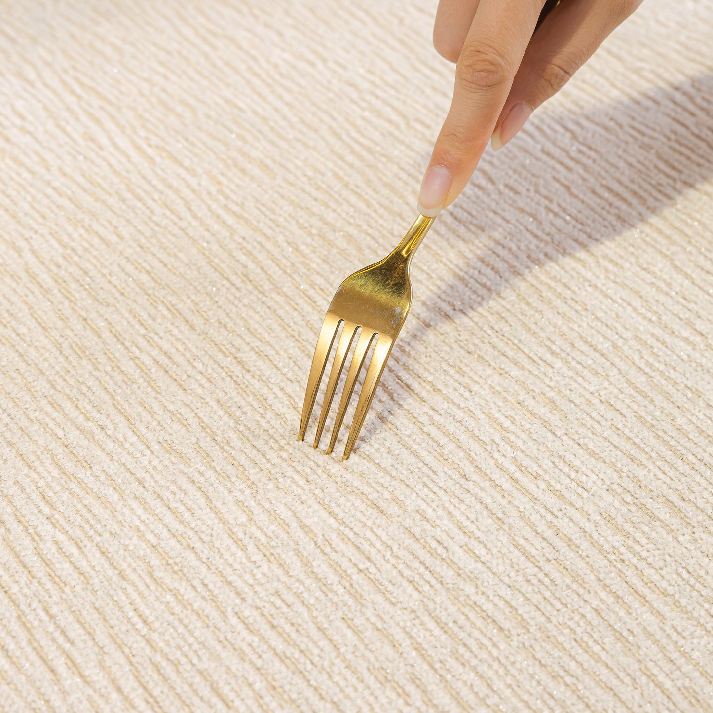 Testing softness of Chenille Couch Cover with Scalloped Edge using a gold fork, showcasing non-slip textured surface.