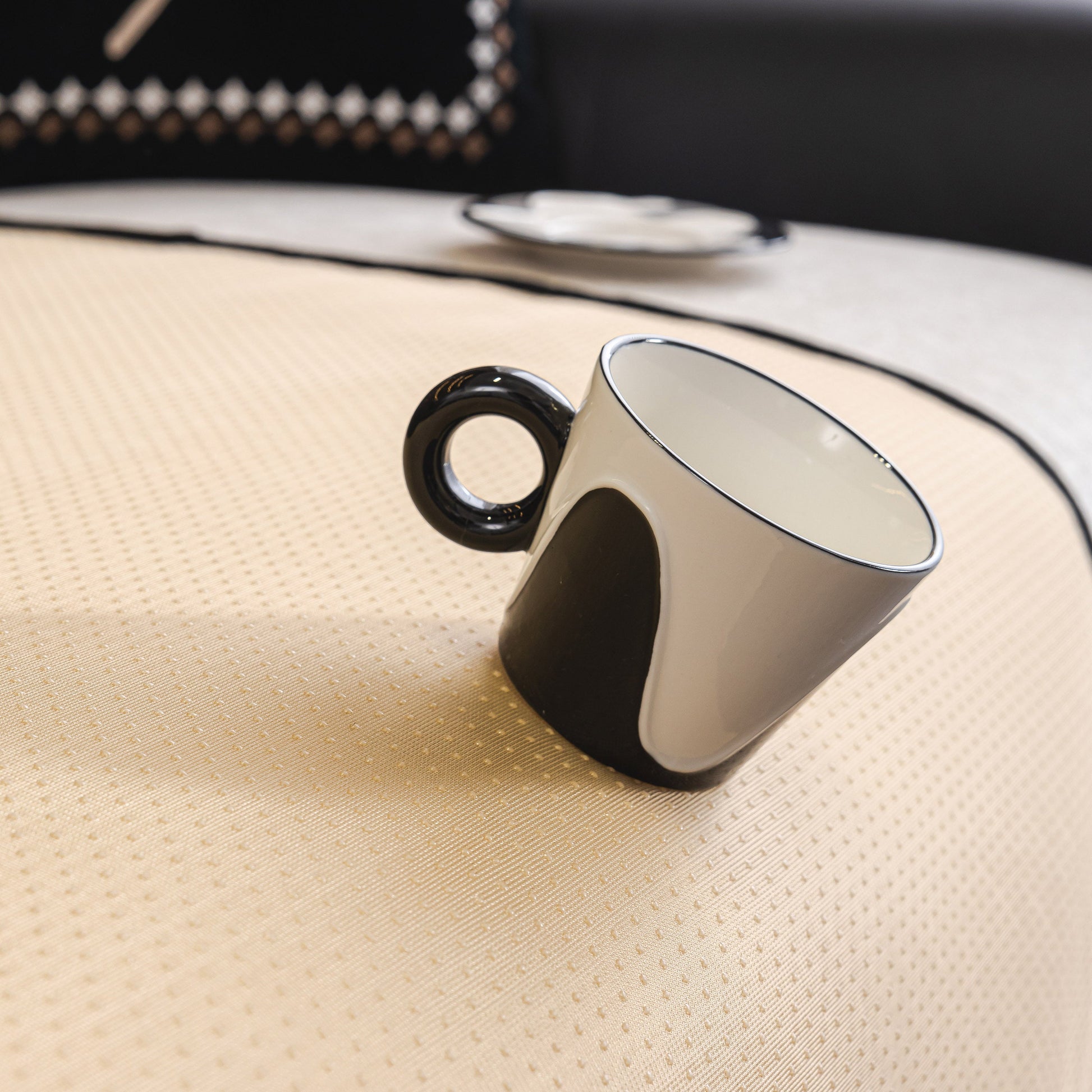 Black and white mug on a textured beige surface with elegant design