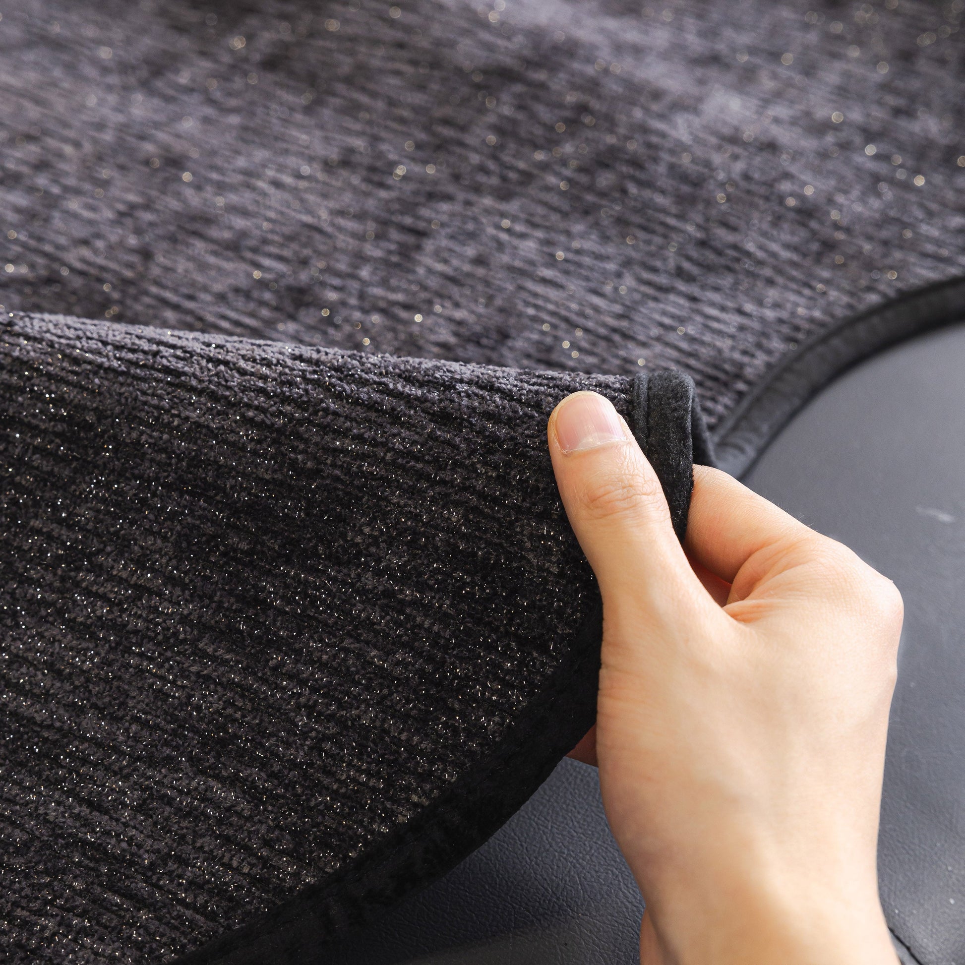 Hand adjusting Chenille Couch Cover with Scalloped Edge, Non-Slip Modular Slipcover Sectional, showing textured fabric detail.