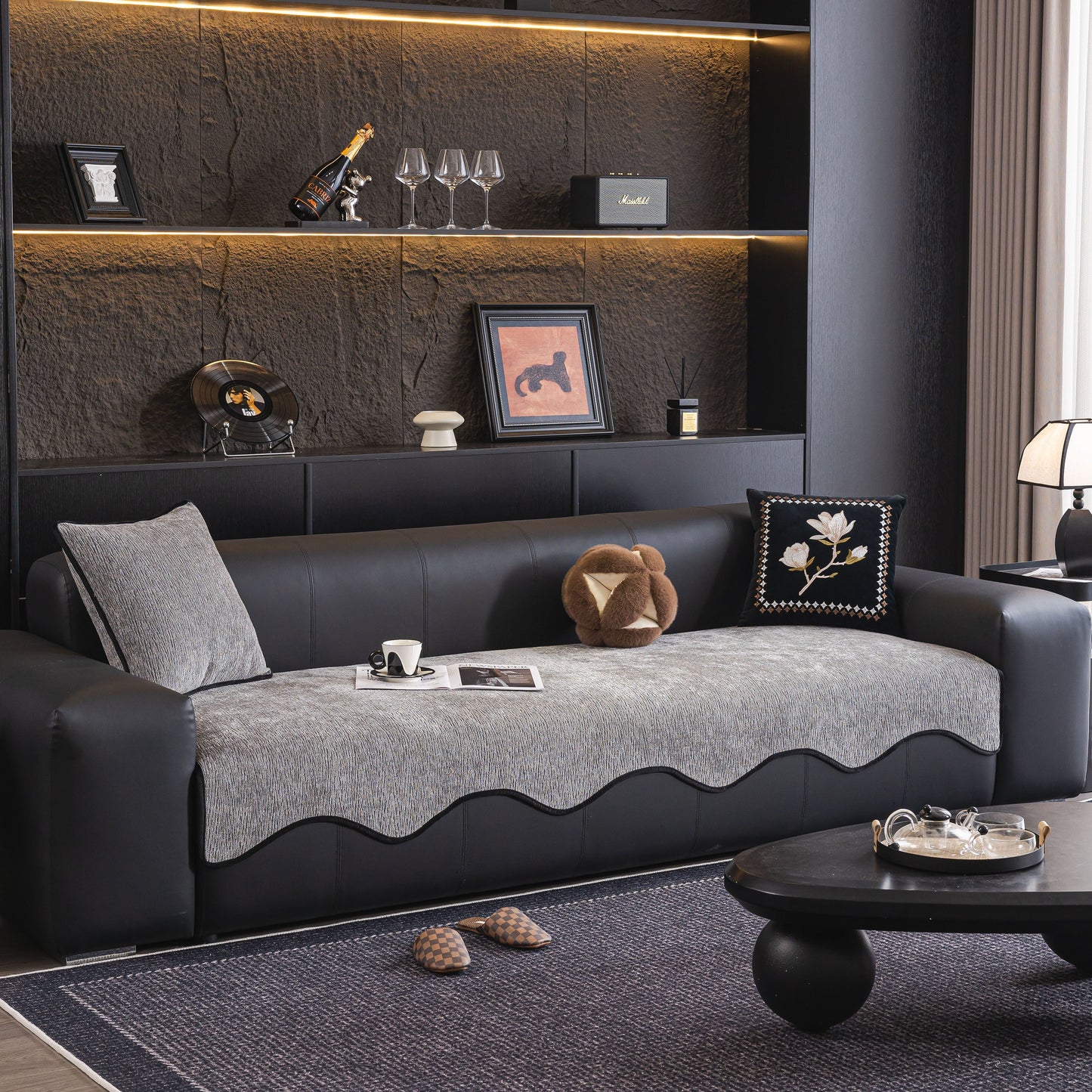 Modern living room featuring Chenille Couch Cover with Scalloped Edge, Non-Slip Modular Slipcover Sectional on a black leather sofa.