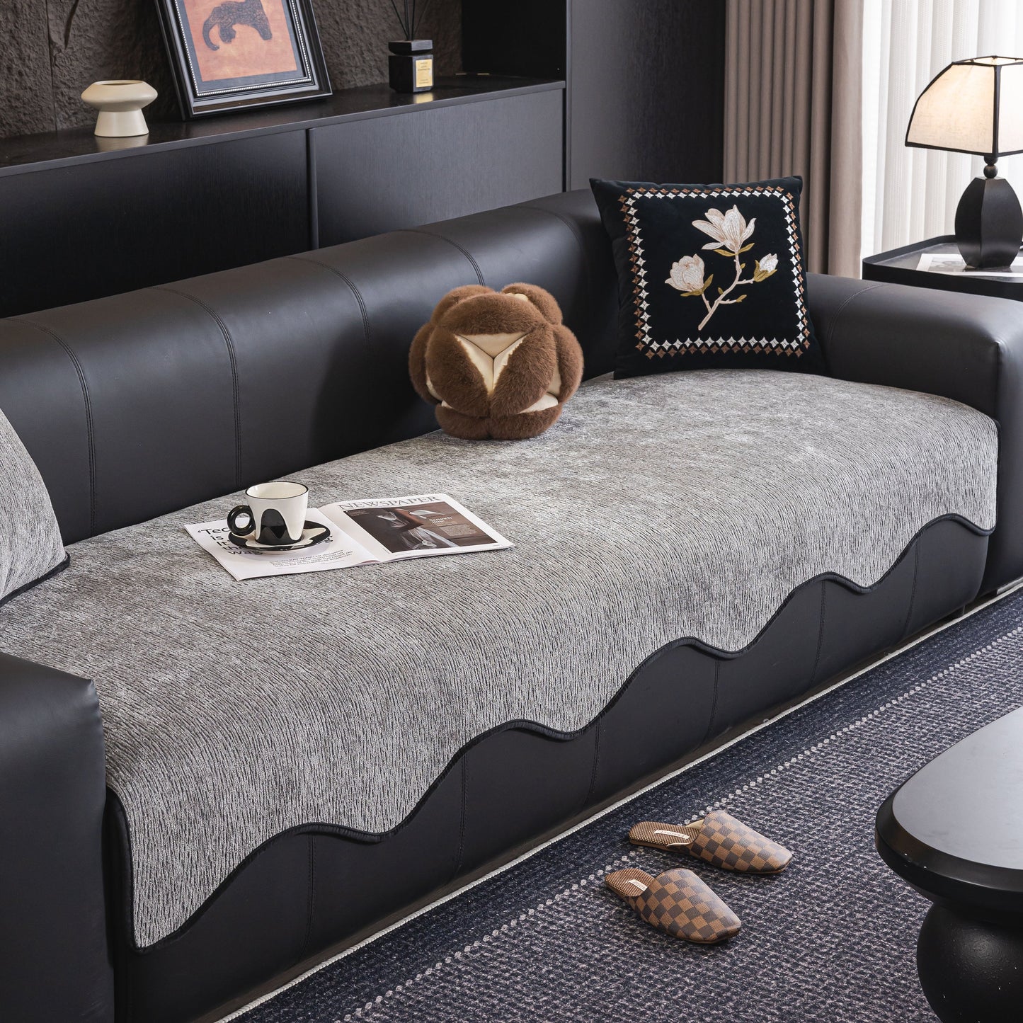 Gray chenille couch cover with scalloped edge on black leather sofa, non-slip modular slipcover sectional.