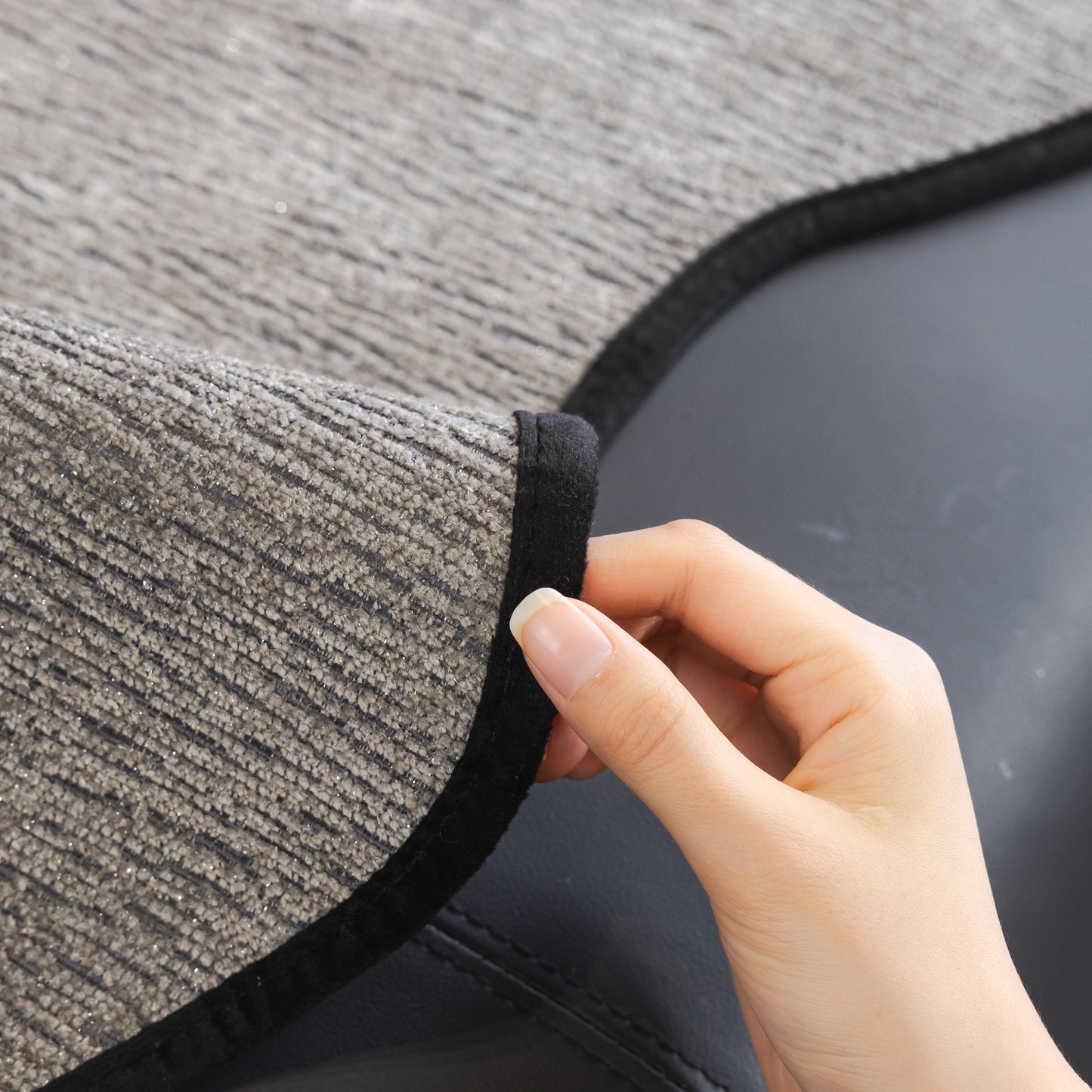 Hand adjusting Chenille Couch Cover with Scalloped Edge, Non-Slip Modular Slipcover Sectional on a sofa.