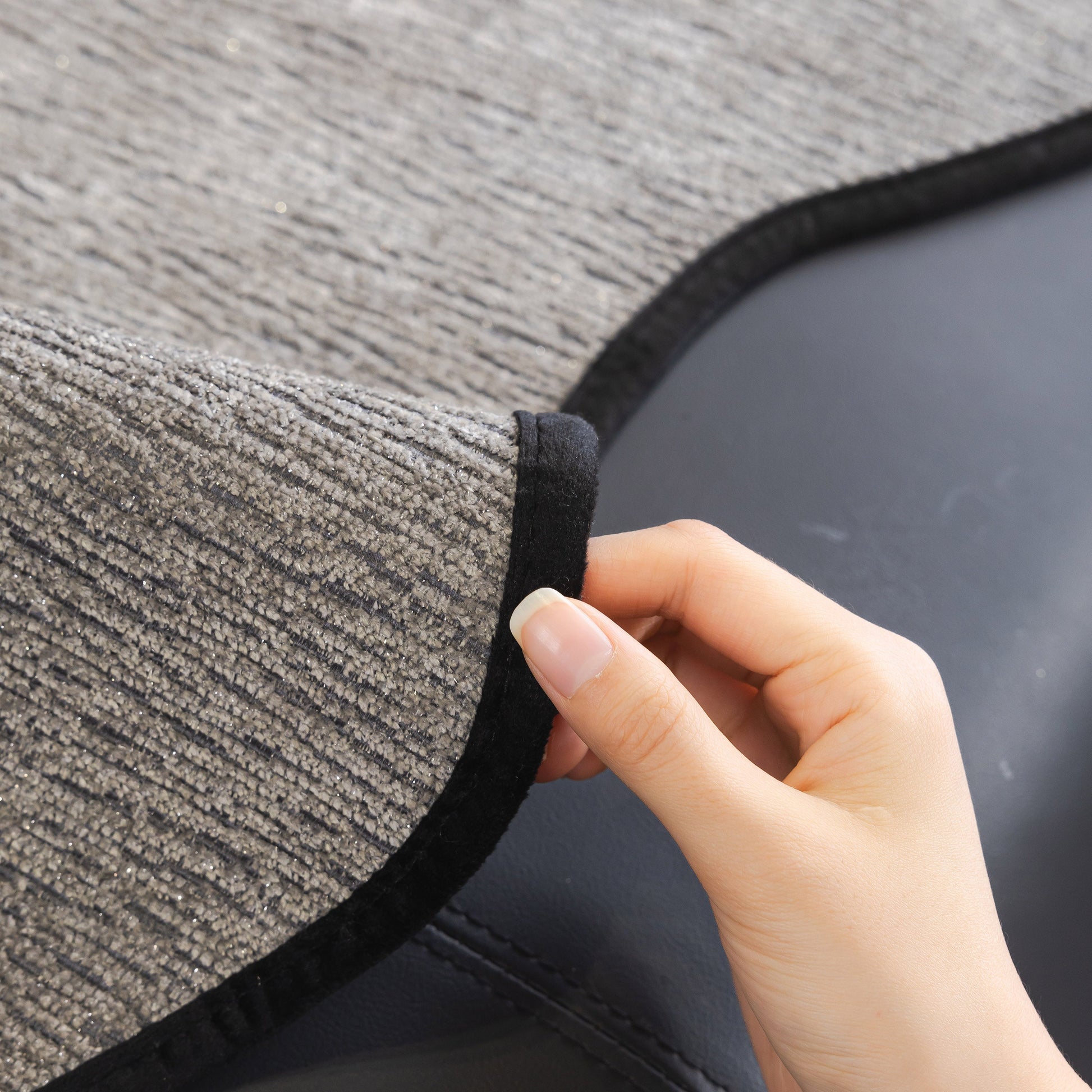 Hand adjusting Chenille Couch Cover with Scalloped Edge, Non-Slip Modular Slipcover Sectional on a sofa.