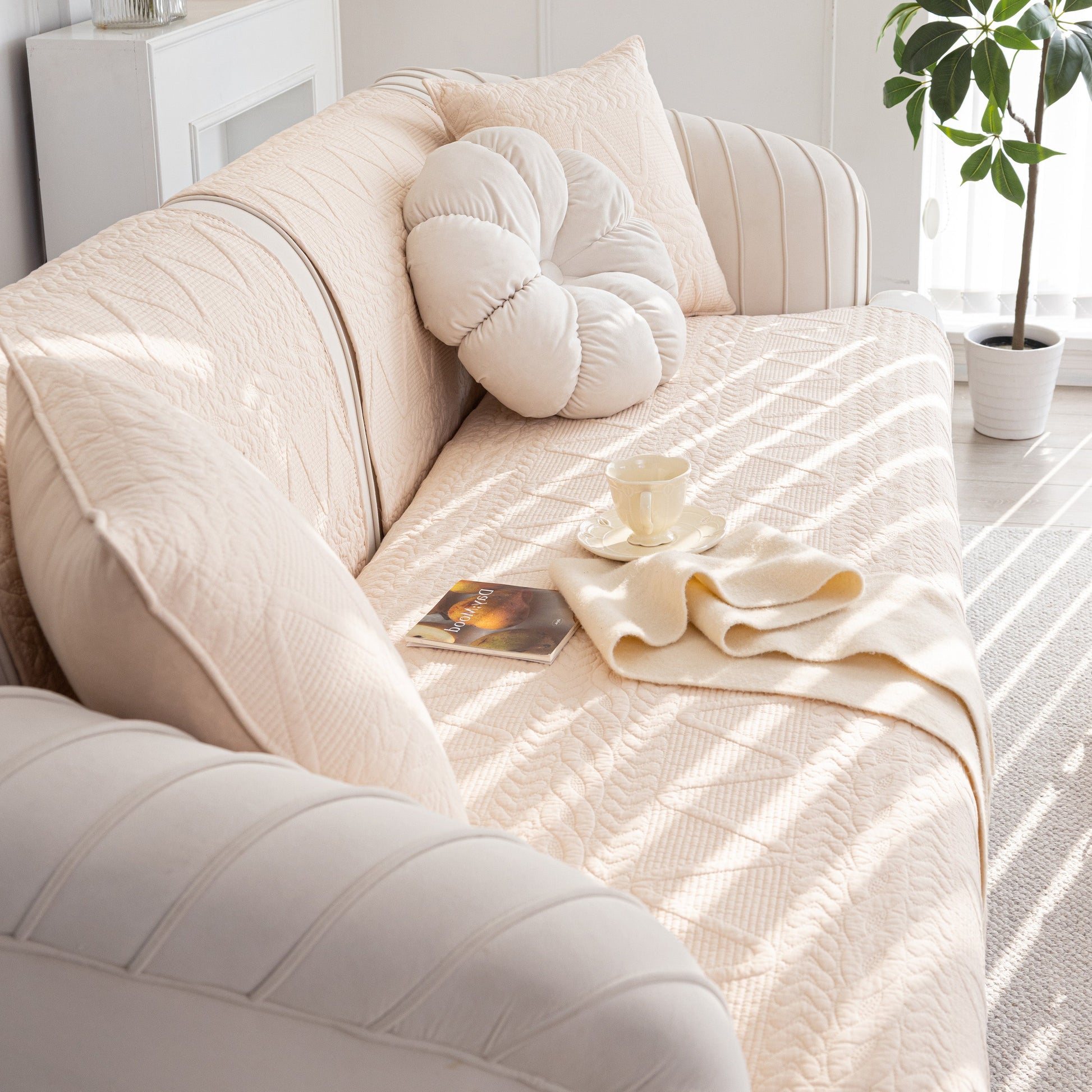 Geometric Textured Cotton Quilted Sofa Cover, Non-Slip Washable Couch Protector on modern beige sofa with decorative pillows and blanket.