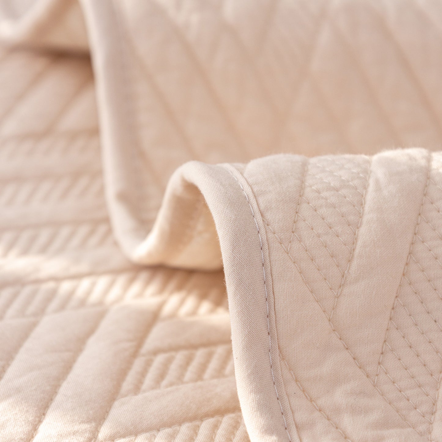 Close-up view of Quilted Geometric Cotton Sofa Cover, Non-Slip & Thick Padded Furniture Covers with textured pattern.
