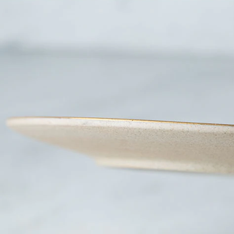 Side view of stylish Galileo Tableware plate with golden rim, handcrafted porcelain, modern matte finish, dishwasher safe.