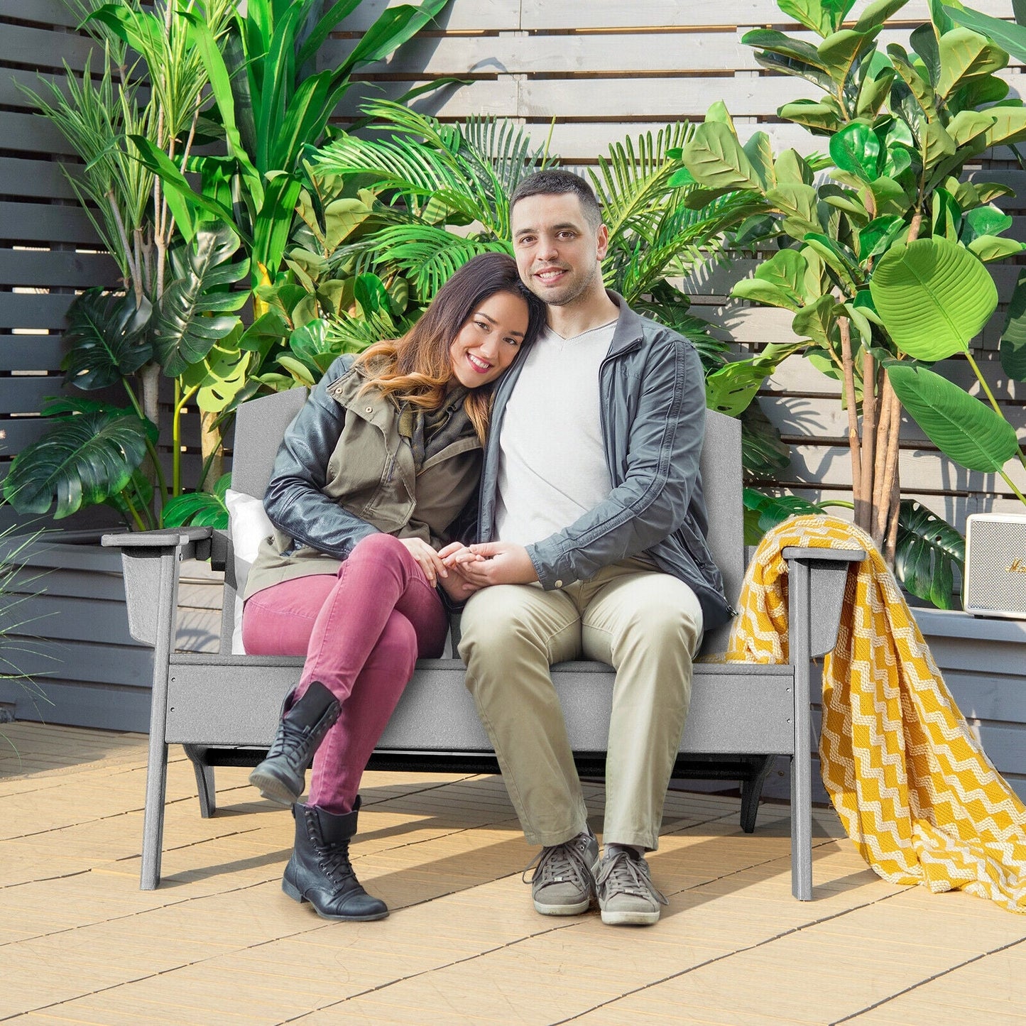 Couple sitting on HDPE Patio Adirondack Chair for Porch Garden Backyard-Gray, surrounded by lush plants