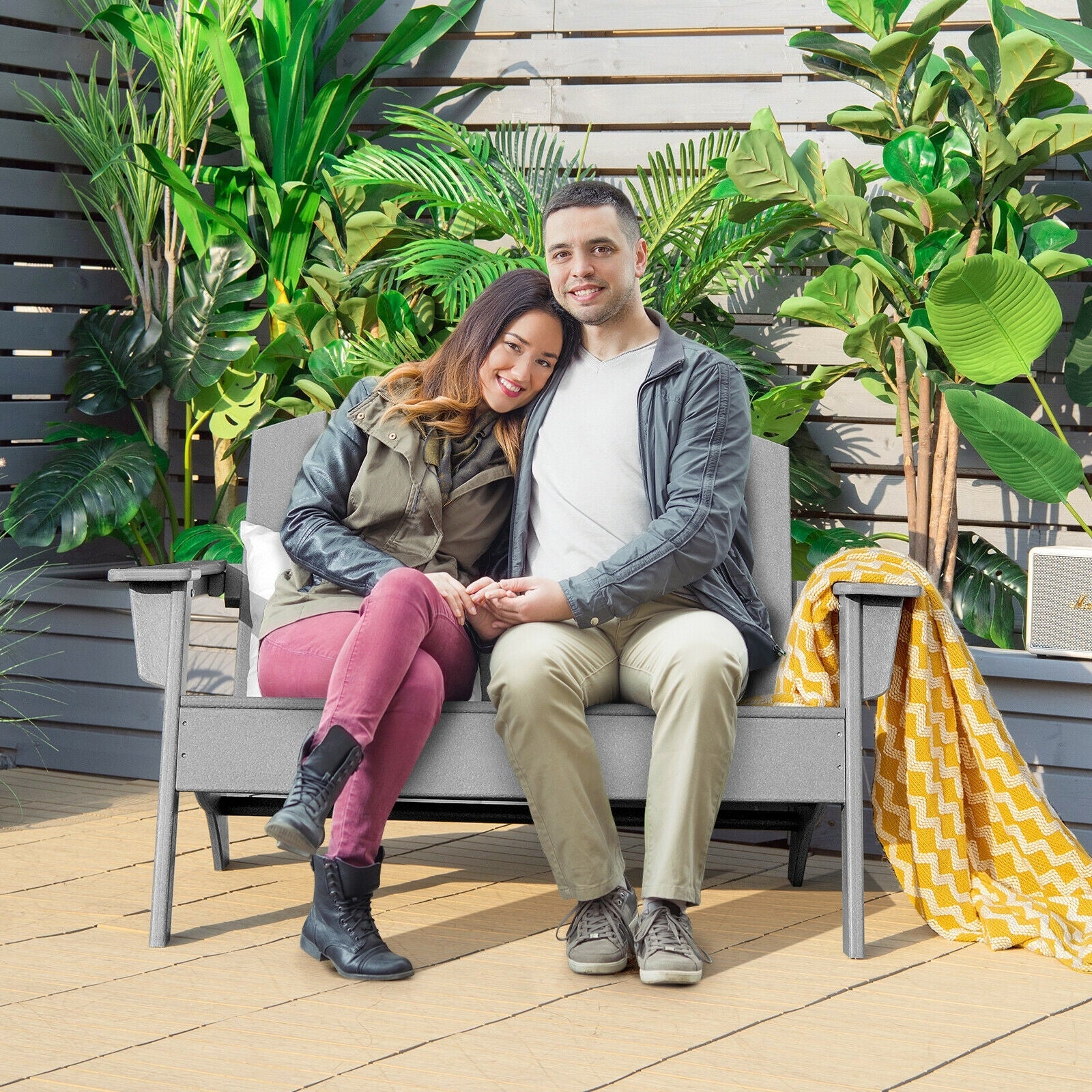 Couple sitting on HDPE Patio Adirondack Chair for Porch Garden Backyard-Gray, surrounded by lush plants