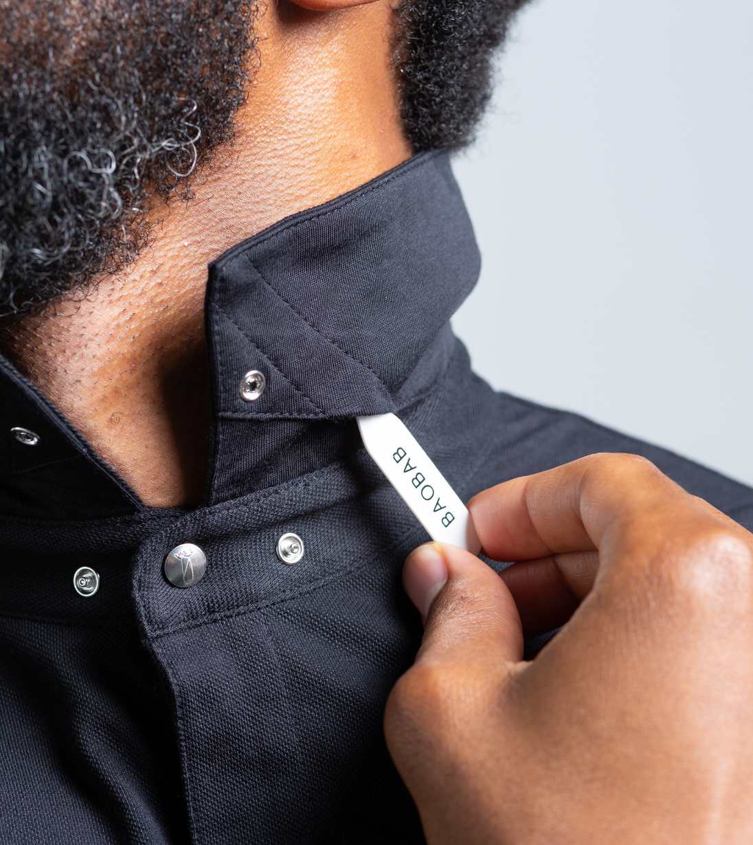Man adjusting StaySharp™ Collar of Long Sleeve Perfect Polo with hidden snaps.