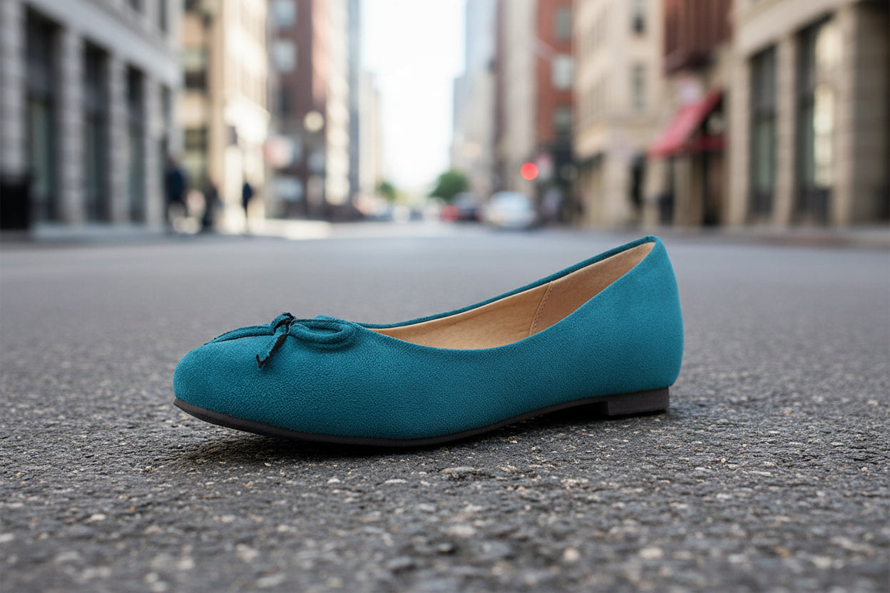 Teal flat shoe on urban street background with soft focus buildings