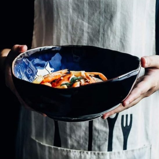 Blue European Porcelain Dinnerware Set (Plates and Bowls) featuring a hand-painted blue bowl with food in a person's hands