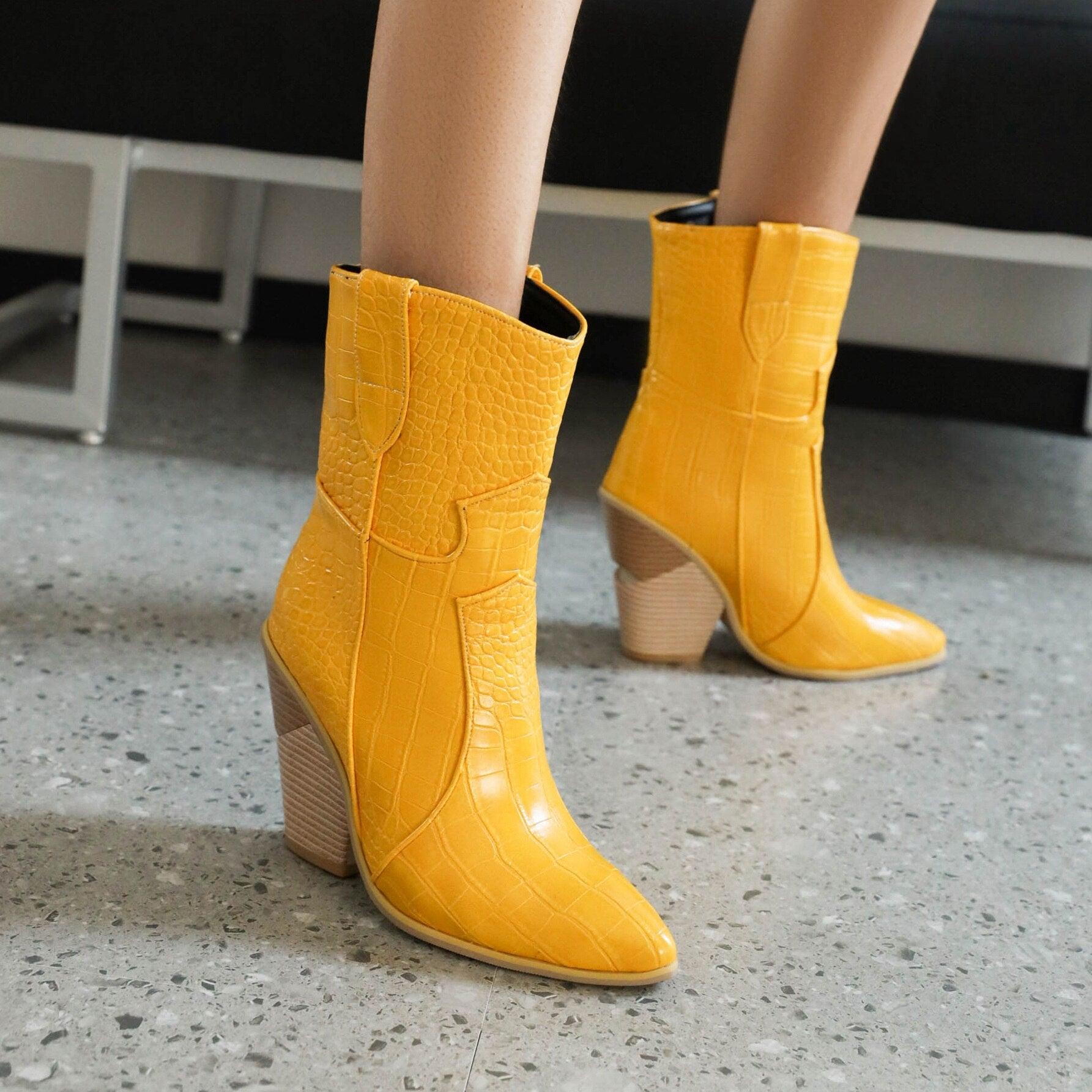 Yellow cowgirl chic high heel ankle boots with textured design on a stylish woman showcasing trendy denim and leather boots for women.