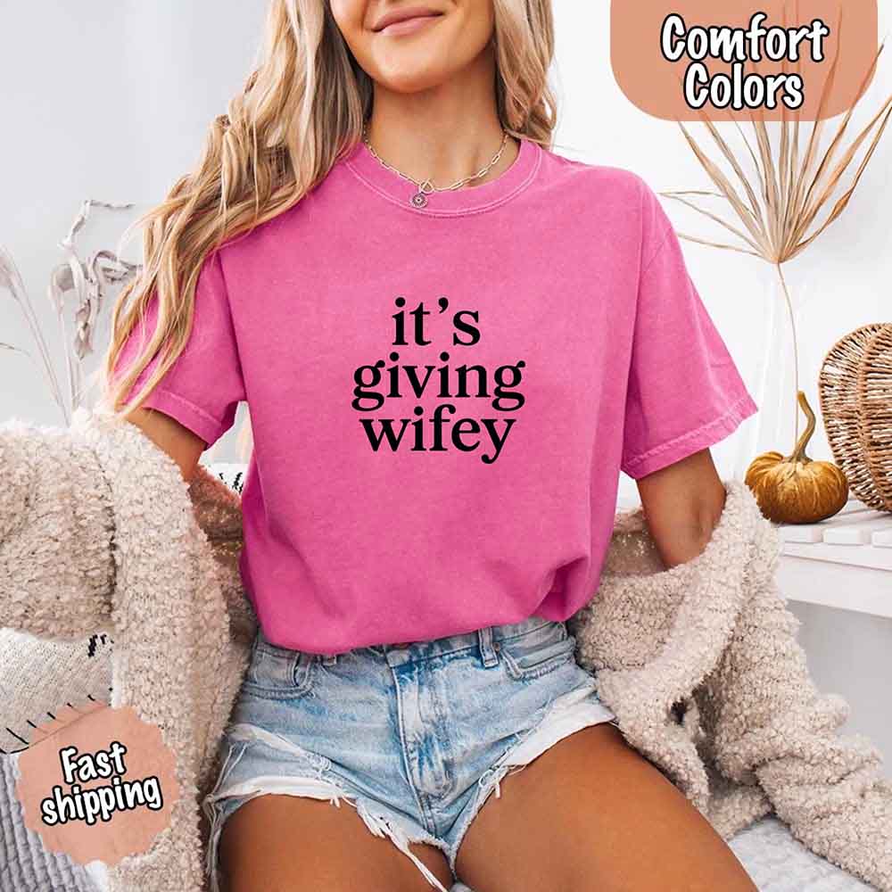 Woman wearing Its Giving Wifey Comfort Colors Tee in pink, styled for bridal occasions. Cozy and stylish look for brides-to-be.