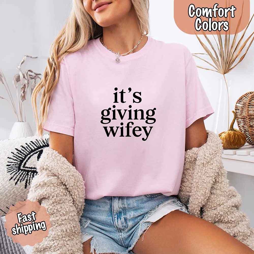 Woman wearing Its Giving Wifey Comfort Colors Tee in pink, perfect bride or wedding gift shirt with fast shipping.