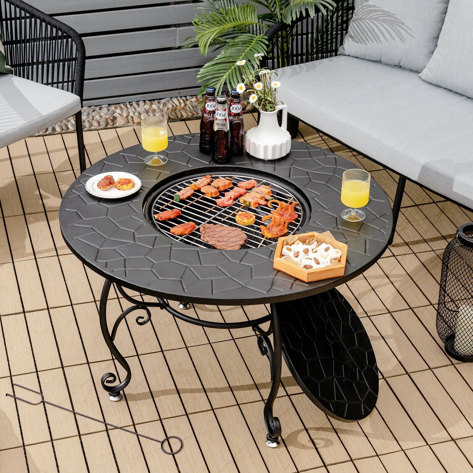 35.5 Feet Patio Fire Pit Dining Table With Cooking BBQ Grate on a deck with food and drinks.