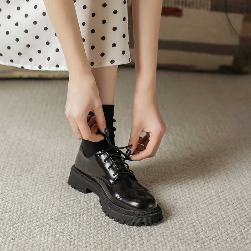 Woman tying Women’s Solid-Color Retro Slip-On Platform Shoes in black, featuring vintage design and modern comfort, on carpeted floor.