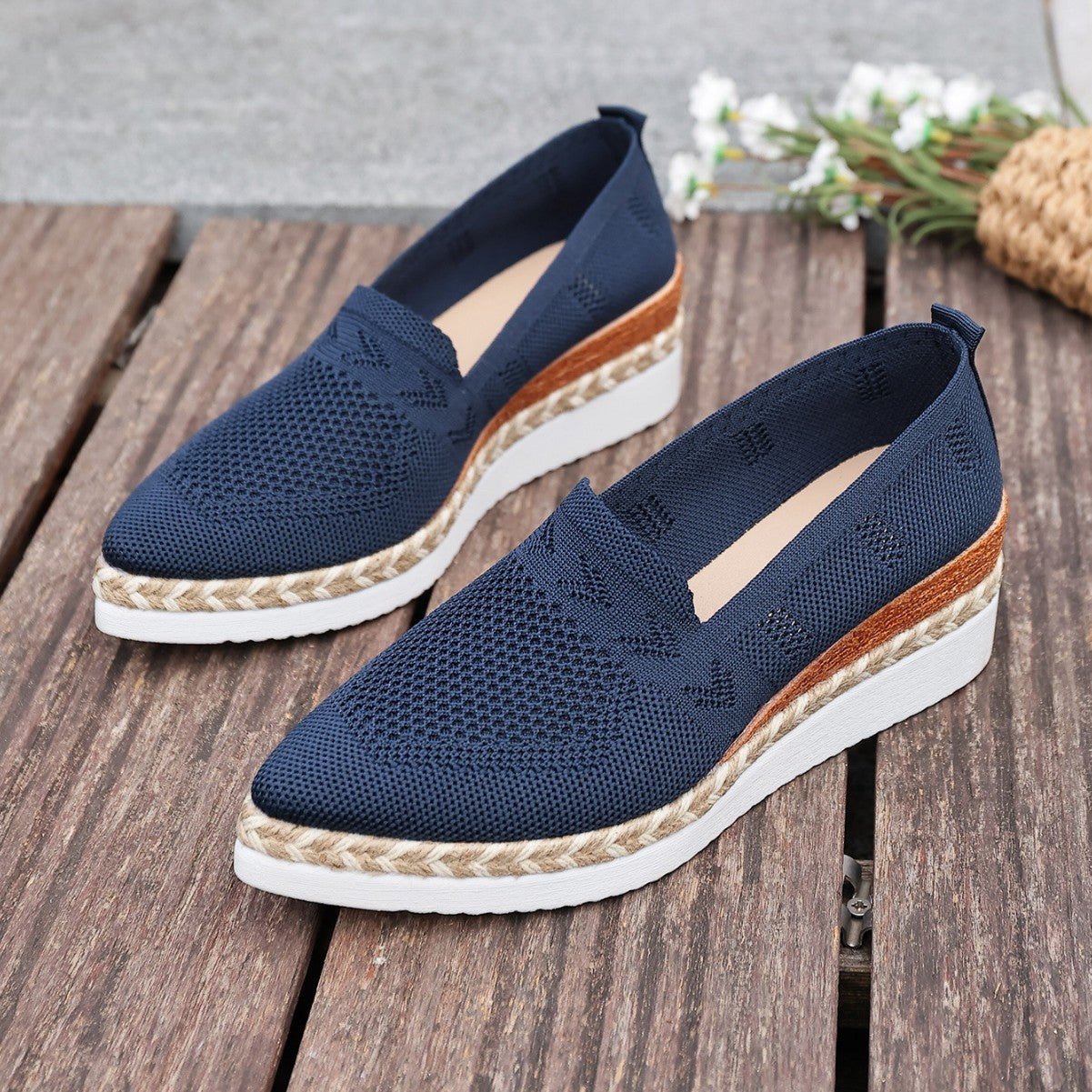 Women’s Woven Rope Platform Snakeskin Pointed-Toe Flats on wooden deck with floral accents