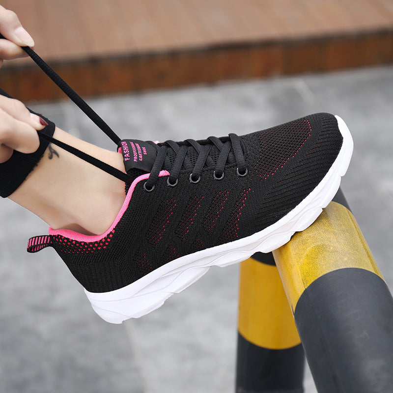 Women's Mesh Running & Travel Sneakers in black and pink being tied, featuring breathable mesh uppers and cushioned soles for comfort.