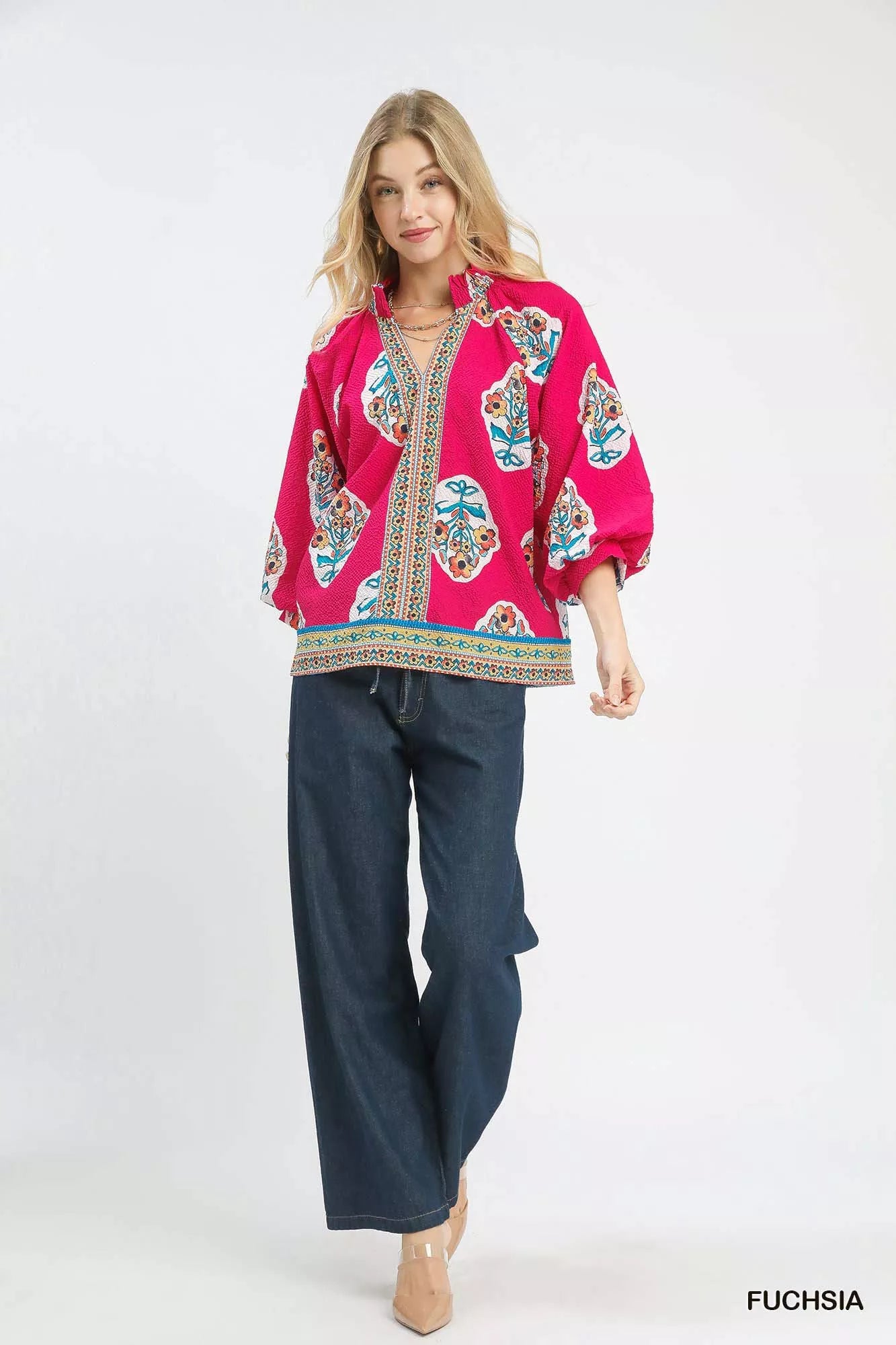 Woman wearing Umgee Boho Floral Print Tunic Blouse with 3/4 sleeves and vibrant design in fuchsia.